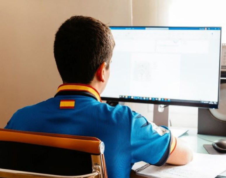 live online, man in blue shirt sitting and looking at microsft word on a computer screen 